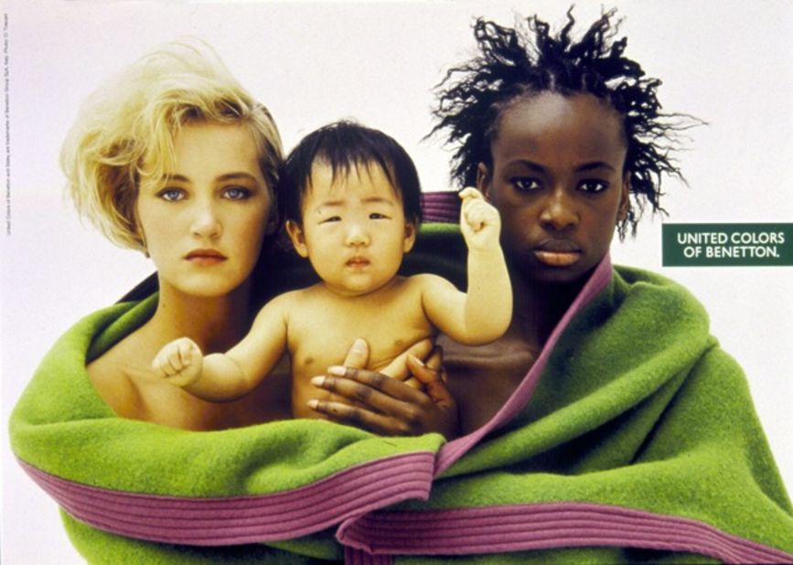 Oliviero Toscani equally challenged racial segregation within society, often placing people of different ethnicities alongside each other in family settings --  which still at that time had the power to shock. Here, he equally challenged heteronormativity; supposing the women depicted are both mothers of the child, in a two-fold challenge of societal norms.