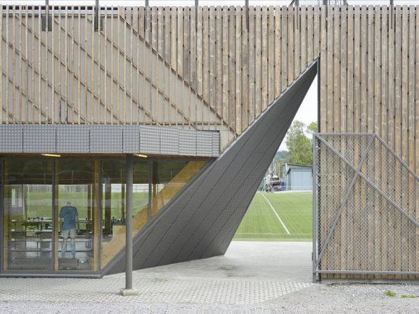 One part of the building contains a coffee shop, meeting rooms and offices. The other contains changing rooms. The middle section splits the sections -- creating an entrance into the building as well as a gateway to the field. 