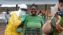 A health worker, wearing Personal Protective Equipment (PPE), and a woman pose on September 7, 2014 inside the high-risk area at Elwa hospital in Monrovia, which is run by the non-governmental  international organization Medecins Sans Frontieres (Doctors without Borders -- MSF). US President Barack Obama said in an interview aired on September 7 the US military would help in the fight against fast-spreading Ebola in Africa, but warned it would be months before the epidemic slowed. The tropical virus, transmitted through contact with infected bodily fluids, has killed 2,100 people in four countries since the start of the year -- more than half of them in Liberia.   AFP PHOTO / DOMINIQUE FAGET        (Photo credit should read DOMINIQUE FAGET/AFP/Getty Images)
