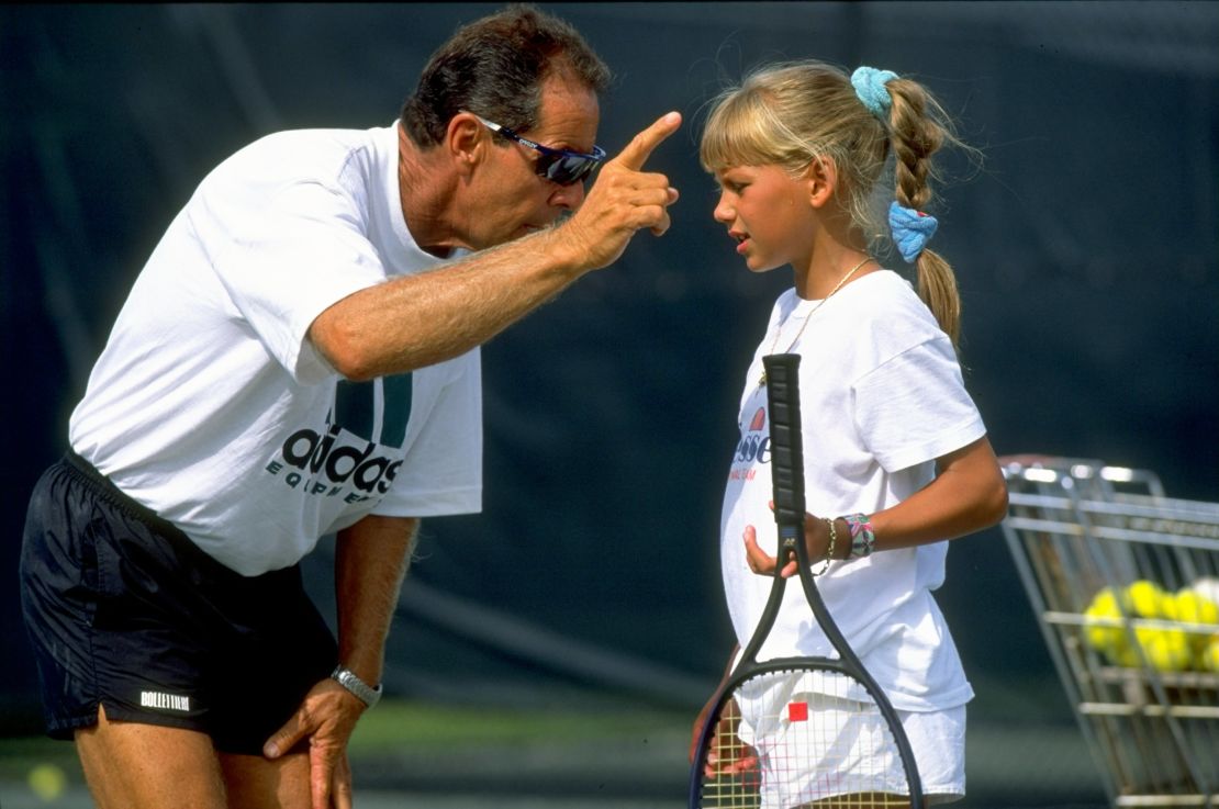 Coach Nick Bollettieri gives instructions to a young Anna Kournikova during training at his academy.