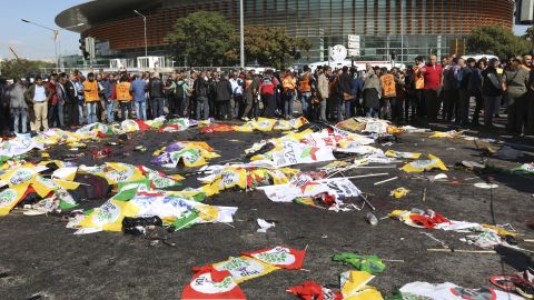 People surround the area where bodies of victims are covered with flags and banners.