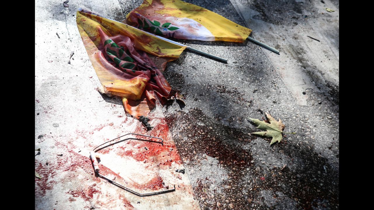 Bloodstained flags lie on the ground at the site of the explosion.