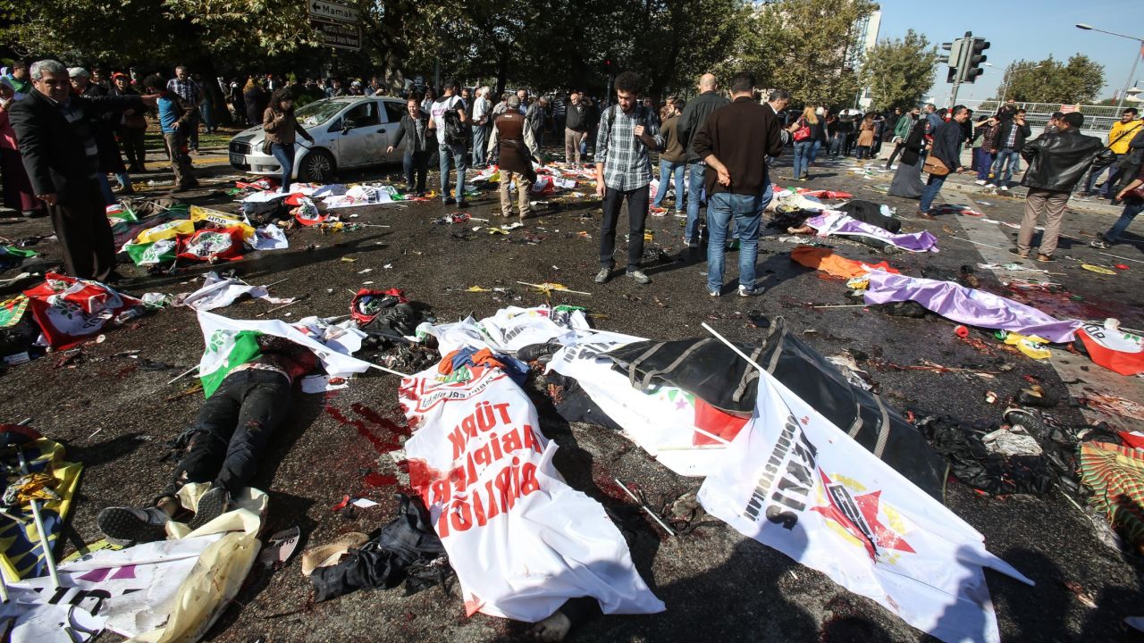 Bodies lie covered with flags and banners at the blast site.