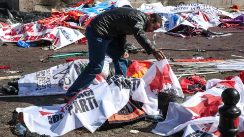 A man looks at a body at the site of the explosion.