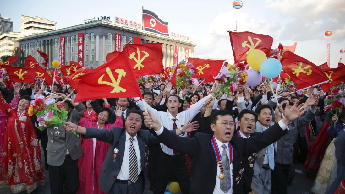 North Koreans parade with flags of the ruling Workers' Party.