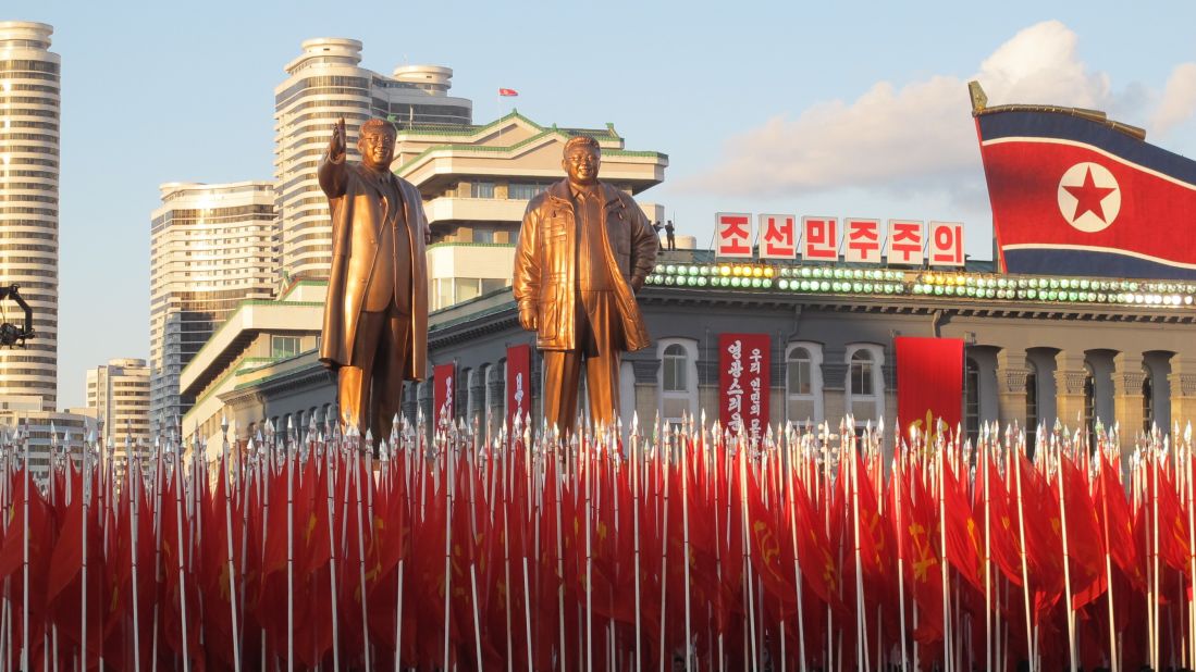 North Korean soldiers march below statues of North Korean founder Kim Il Sung and his son, Kim Jong Il.
