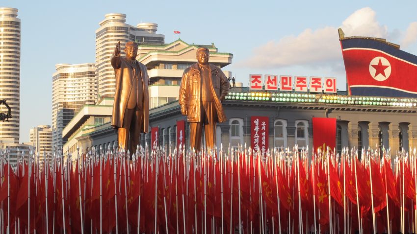 North Korean soldiers march below statues of North Korea's founding president Kim Il-sung and his son Kim Jong-il.