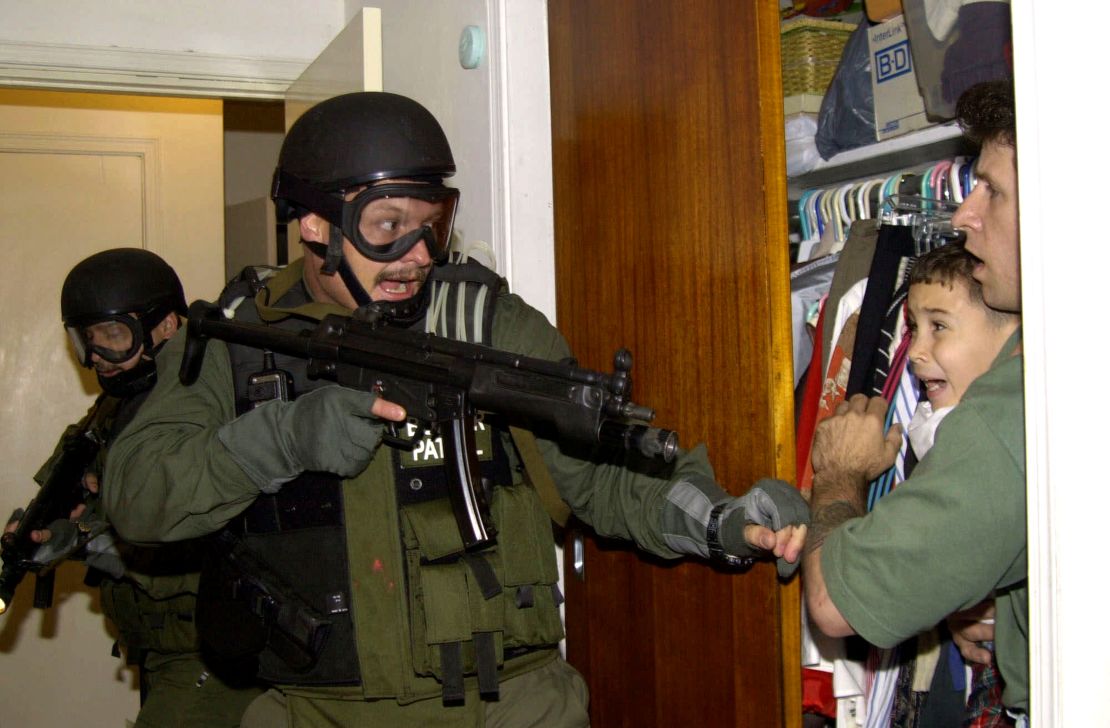 In this iconic photo, a federal agent participates in the raid to remove Elian Gonzalez from his relatives' home in Miami on April 22, 2000.