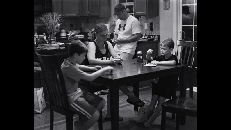 A family is gathered around the kitchen table but distracted from one another by invisible mobile devices. "I'm hoping there are going to be some families that see this work and they put a basket by the door and the phones go in it before they all sit down to dinner," Pickersgill said. 