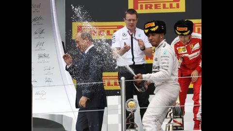 Russian President Vladimir Putin joins Formula One driver Lewis Hamilton on the podium after Hamilton won the Russian Grand Prix on Sunday, October 11.