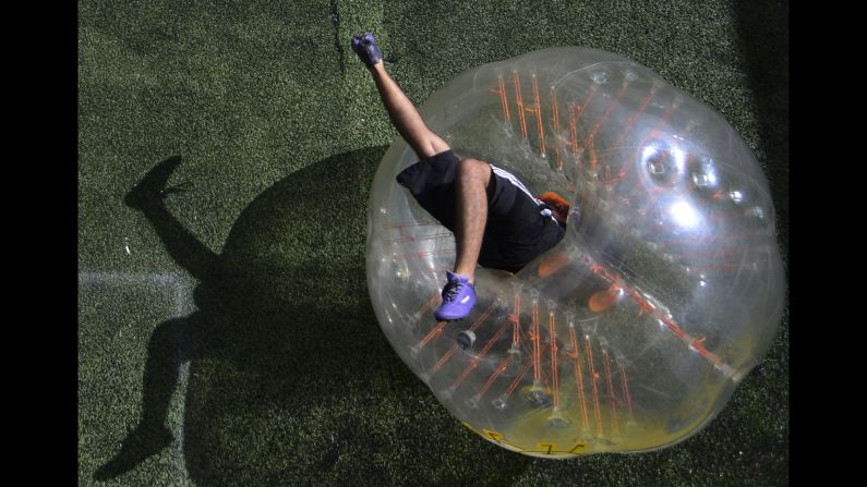 A man plays bubble soccer in Medellin, Colombia, on Saturday, October 10. In bubble soccer, players wear plastic balls over their upper bodies and crash into one another. <a href="index.php?page=&url=http%3A%2F%2Fwww.cnn.com%2Fvideos%2Fliving%2F2014%2F10%2F31%2Fbubblesoccer.cnn" target="_blank">Check out this video to see bubble soccer in action</a>