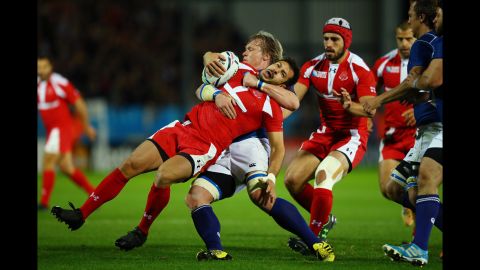 Georgia's Lasha Malaghuradze is pulled down by Namibia's Renaldo Bothma during a Rugby World Cup match in Exeter, England, on Wednesday, October 7.