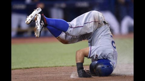 Rougned Odor, second baseman for the Texas Rangers, lands after flipping at home plate to avoid a tag Friday, October 9, in Toronto. Odor scored on a sacrifice fly for the Rangers, who took a 2-0 lead over Toronto in the American League Division Series.