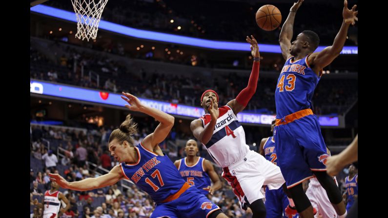 Washington Wizards forward Toure' Murry, center, shoots between New York Knicks Lou Amundson, left, and Thanasis Antetokounmpo during an NBA preseason game Friday, October 9, in Washington.
