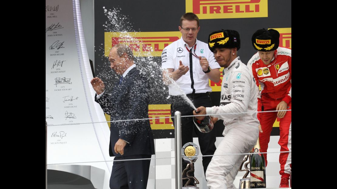 Lewis Hamilton soaks Vladimir Putin in champagne as he celebrates victory at the 2015 Russian GP
