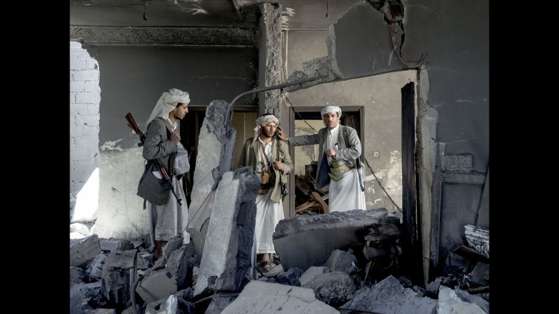 Three fighters stand in the rubble of a sheik's home in September.