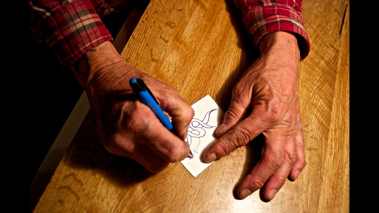 Faron Sr. doodles on a small piece of paper at his home. He said he loves to draw different shapes and patterns as a form of stress relief.