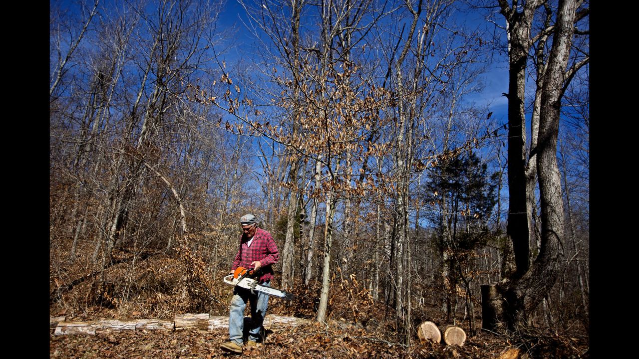 Faron Sr. spends his morning cutting down trees to be later used as firewood.