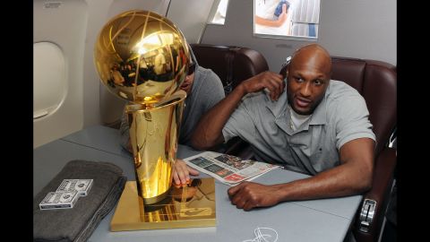 Odom sits next to the Larry O'Brien Trophy during the Lakers' flight back to Los Angeles in June 2009. The Lakers defeated the Orlando Magic for the NBA championship.