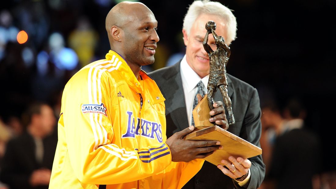 Odom receives the Sixth Man of the Year Award from Lakers general manager Mitch Kupchak in April 2011. The award honors the NBA's best player in a reserve role.
