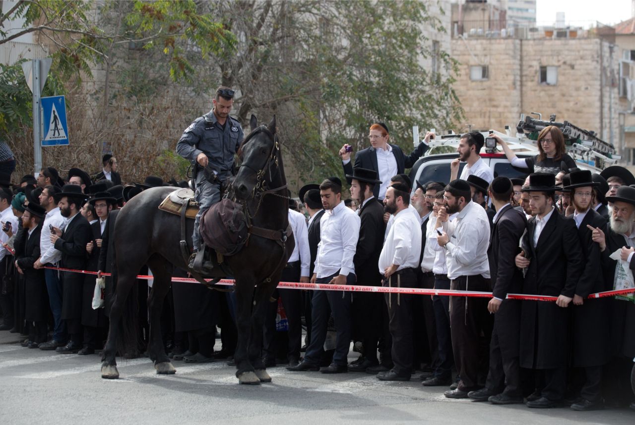 A member of Israel's security forces cordons off the site in Jerusalem where a Palestinian man drove into a bus stop and carried out a stabbing attack on October 13.