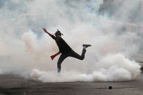 A Palestinian protester in Bethlehem throws a tear-gas canister back at Israeli security forces on October 12.