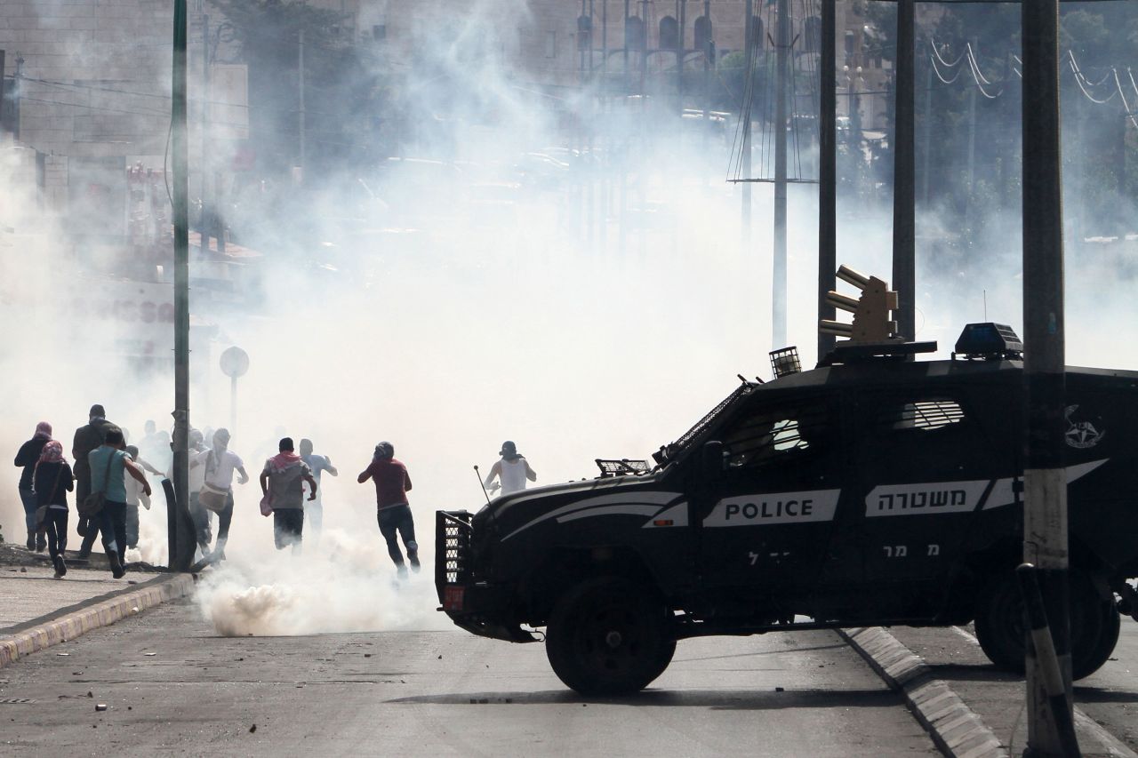 An Israeli police vehicle drives in front of Palestinian protesters in Bethlehem on October 13.
