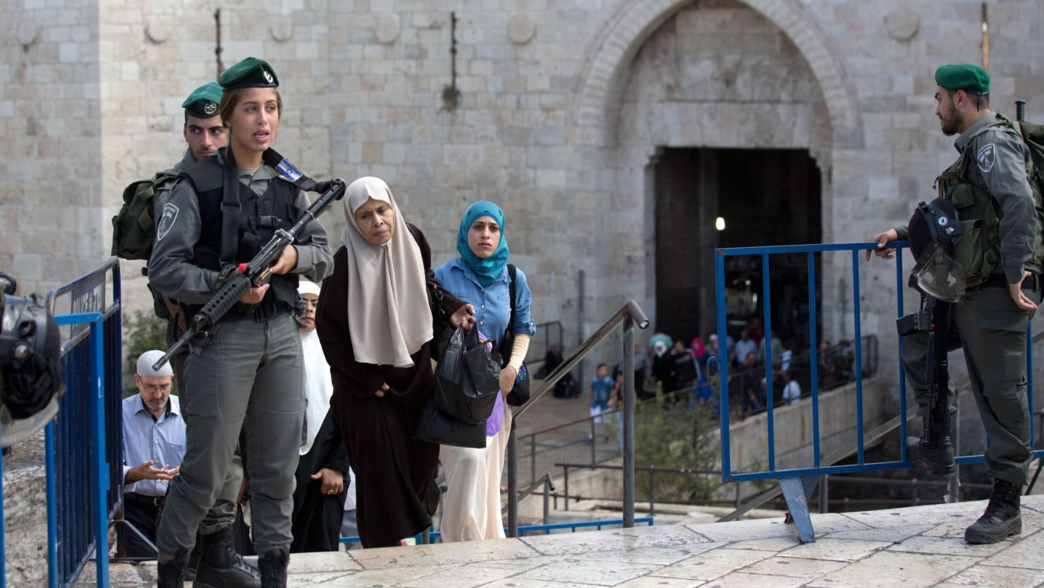 Palestinian women walk past Israeli border police at the Damascus Gate at the entrance of the Old City in East Jerusalem in 2015.