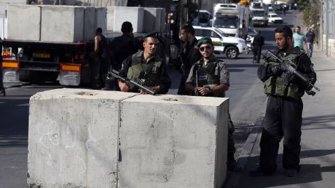 Israeli security forces gather at the site where a road block is being set up.