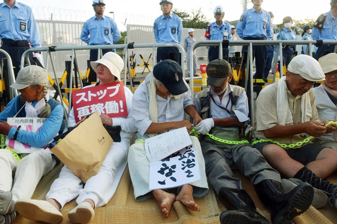 People stage a sit-in rally outside the gates of the Kyushu Electric Power Sendai nuclear power plant on August 11, 2015, as the first reactor was brought back online.