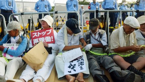People stage a sit-in rally outside the gates of the Kyushu Electric Power Sendai nuclear power plant on August 11, 2015, as the first reactor was brought back online. Restarts are part of a raft of unpopular policies that are being pushed by Abe's government.