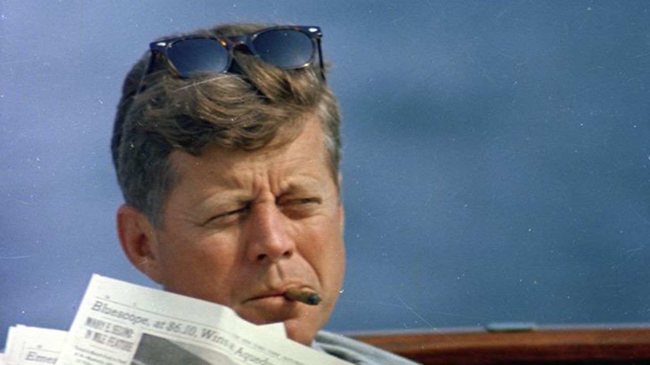 Kennedy reads the newspaper aboard the presidential yacht Honey Fitz off the coast of Hyannis Port, Massachusetts.