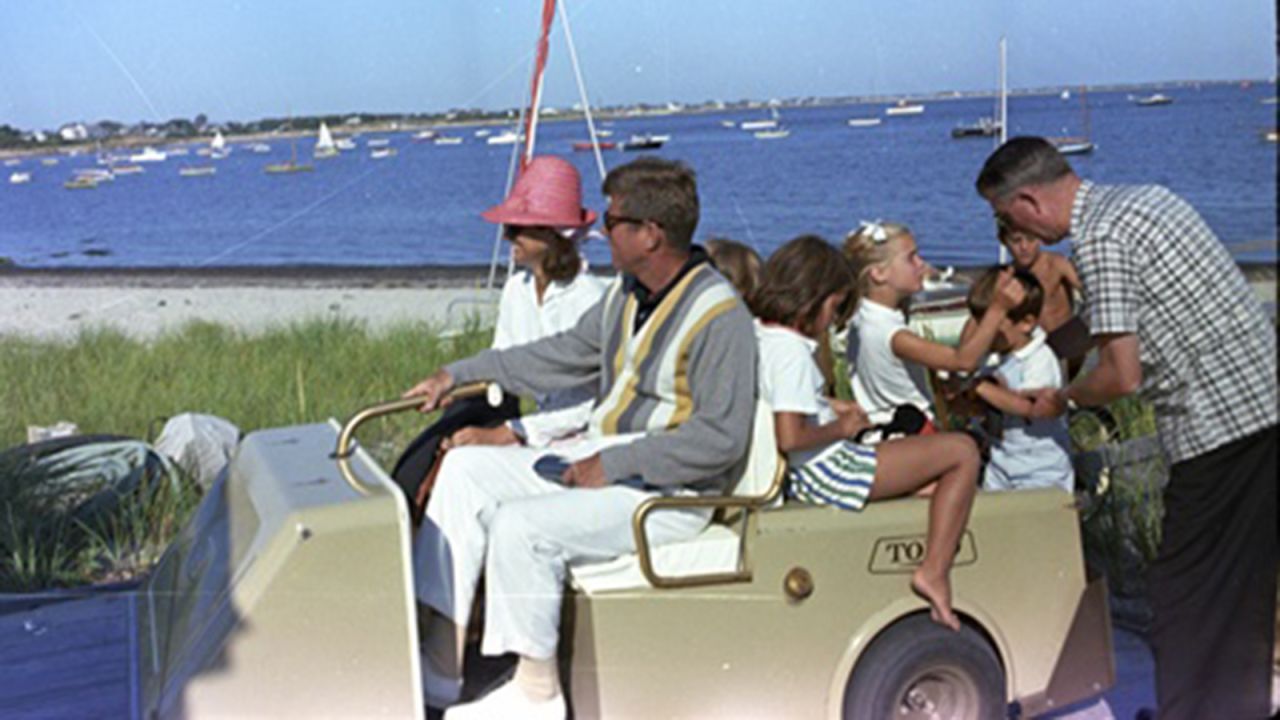 Kennedy steers a golf cart in Hyannis Port, Massachusetts, with Jacqueline, Maria Shriver, Sydney Lawford, Tim Shriver and John Jr.