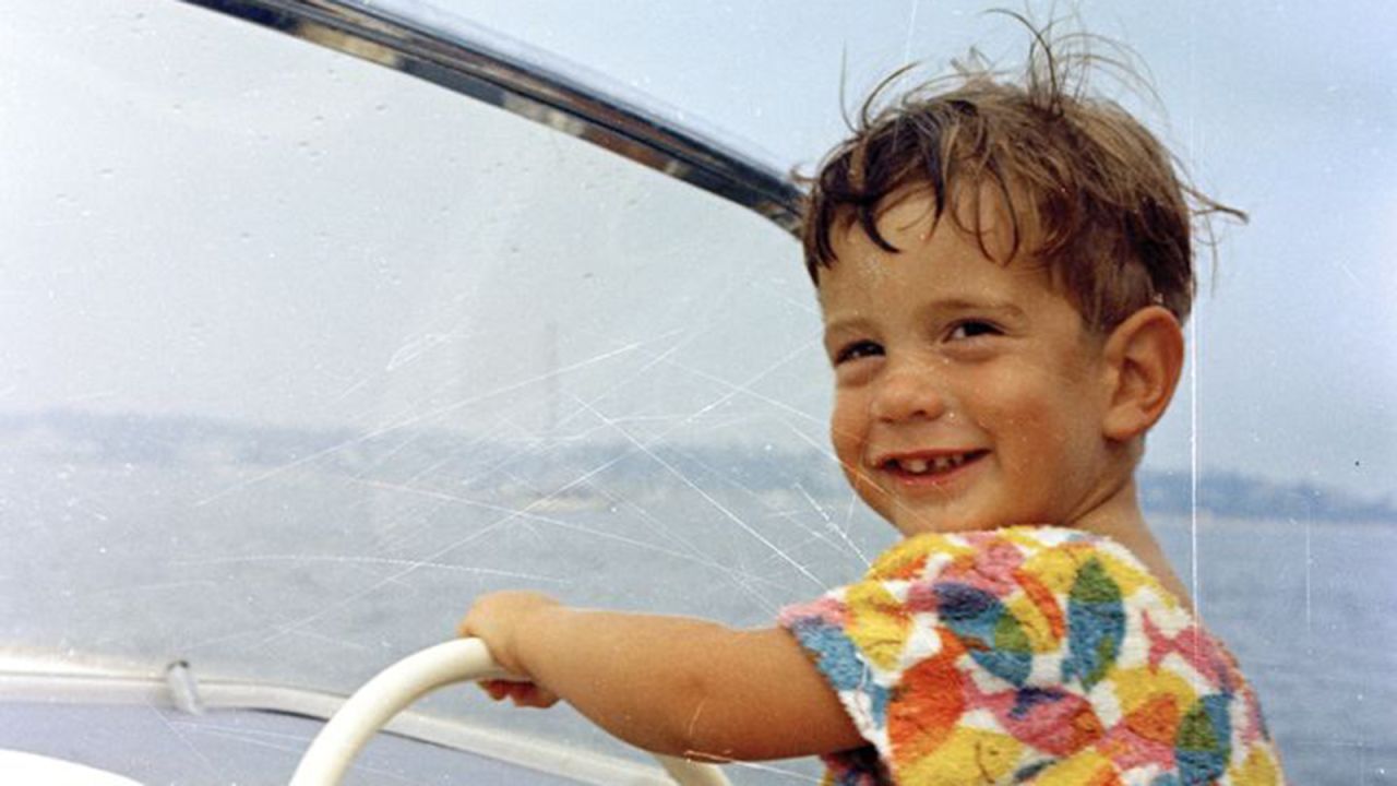 John Jr. smiles at the wheel of a boat off the coast of Hyannis Port, Massachusetts.