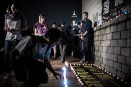 Tsang looks on as supporters lay candles at the spot where he was allegedly beaten by police in Hong Kong on late October 14, 2015. 