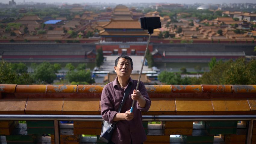 An elderly man uses a selfie stick to take a photo at a park near the Forbidden City in Beijing on May 3, 2015. China will create a "blacklist" of its tourists who behave badly overseas, state-media reported, after several embarrassing incidents involving Chinese travelling abroad. AFP PHOTO/ WANG ZHAO        (Photo credit should read WANG ZHAO/AFP/Getty Images)