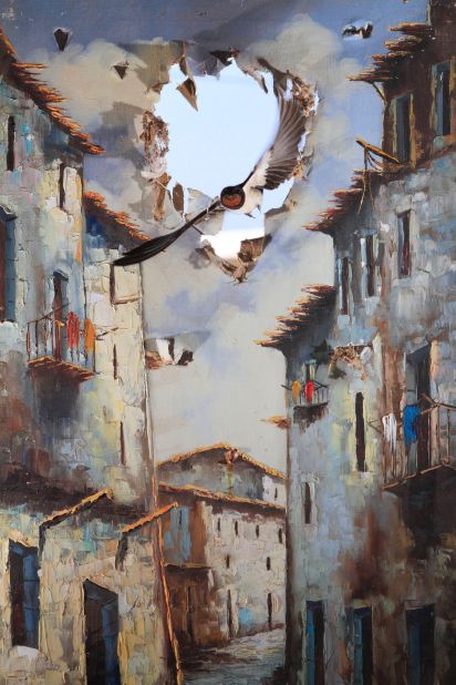 Impressions winner - 'Life comes to art', by Juan Tapia, Spain. <br /><br />Every summer, barn swallows return to nest in an old storehouse on Juan's farm. So he hung a ripped oil painting before a shattered window through which he knew the birds entered. Eight hours later, using remote control, he caught this moment, as though the bird had punched in from another world. 