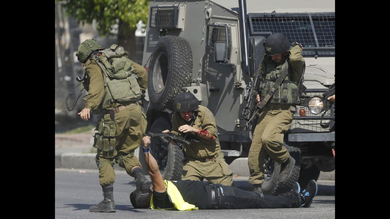An Israeli soldier runs to help another who was just stabbed by an alleged Palestinian assailant, seen on the ground holding a knife, during clashes in Hebron, West Bank, on Friday, October 16. In recent weeks, there has been a spike in violence across Israel and the Palestinian territories. <a href="http://www.cnn.com/2015/10/14/middleeast/israel-palestinians-violence-explainer/index.html" target="_blank">Why now? CNN's Ben Wedeman breaks down the issues</a>