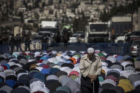 Palestinians kneel during noon prayers in Jerusalem on October 16.