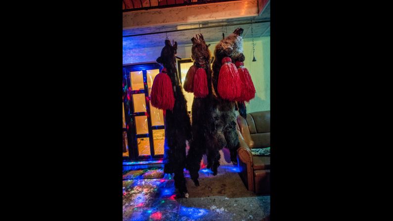At the end of each night, bearskins hang from hooks on the ceiling of a front porch. 