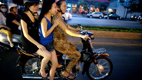 HO CHI MINH CITY, VIETNAM - FEBRUARY 23:  Vietnamese women cruise down the street on a motorcycle February 23, 2011 in Ho Chi Minh City, Vietnam. Over the past year many luxury brands have surfaced in new shopping centers as wealthy Vietnamese spend their money for high priced cars and expensive items. Vietnam has experienced rapid growth since it made a shift to a socialist- oriented market economy, slowly integrating into the world's economy. In 2010 the GDP reached $104.6 billion. According to a forecast by the Pricewaterhouse Coopers in 2008, Vietnam may be the fastest growing of emerging economies by 2025, with a potential growth rate of almost 10% per year.  (Photo by Paula Bronstein /Getty Images)