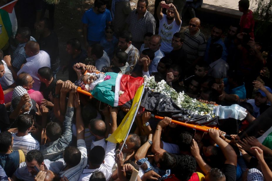 Palestinians carry the body of Iyad Awawdeh, 26, during his funeral in the West Bank village of Dora, near Hebron, on October 17. Awawdeh was killed after he stabbed an Israeli soldier, while posing as a journalist, during clashes Friday.