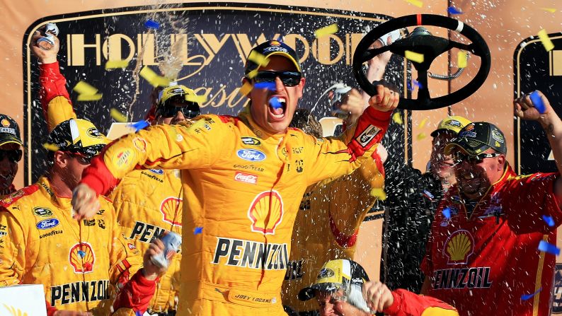 NASCAR driver Joey Logano celebrates with his crew after winning the Sprint Cup race at Kansas Speedway on Sunday, October 18.