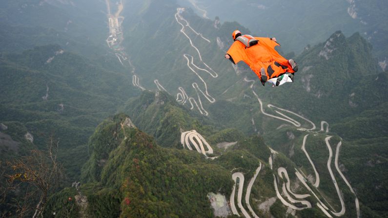 A person wears a wingsuit while flying above China's Tianmen Mountain on Tuesday, October 13.