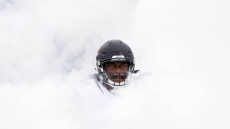 A.J. Cann, an offensive lineman for the NFL's Jacksonville Jaguars, emerges from a cloud of smoke before playing a home game against Houston on Sunday, October 18.