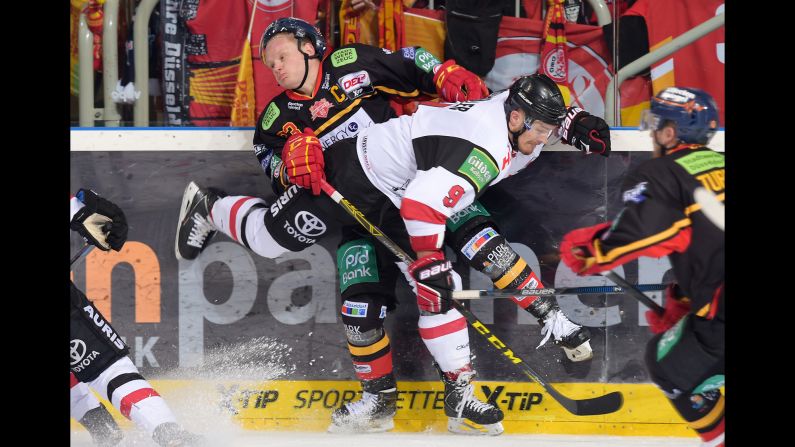 Dusseldorfer's Daniel Kreutzer is crunched by Kolnar Haie's Shawn Lalonde during a hockey game in Dusseldorf, Germany, on Sunday, October 18.