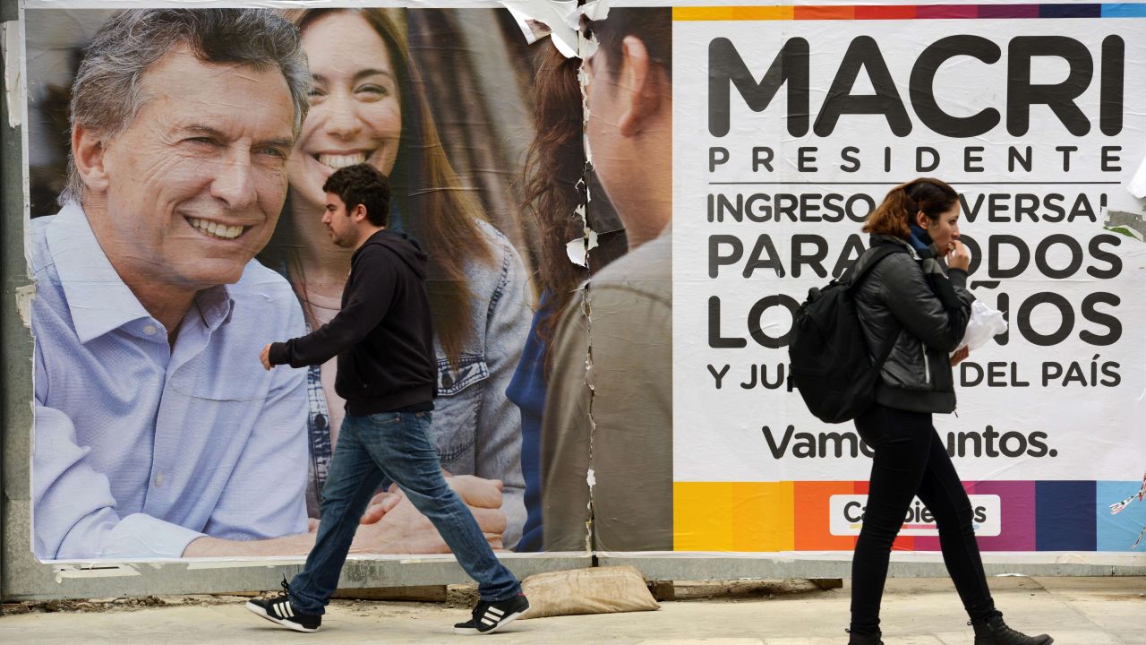 People walk past political propaganda of Buenos Aires Major and presidential candidate for Cambiemos party Mauricio Macri in Buenos Aires on October 19, 2015. General elections will be held next October 25 in Argentina. AFP PHOTO/Eitan Abramovich        (Photo credit should read EITAN ABRAMOVICH/AFP/Getty Images)