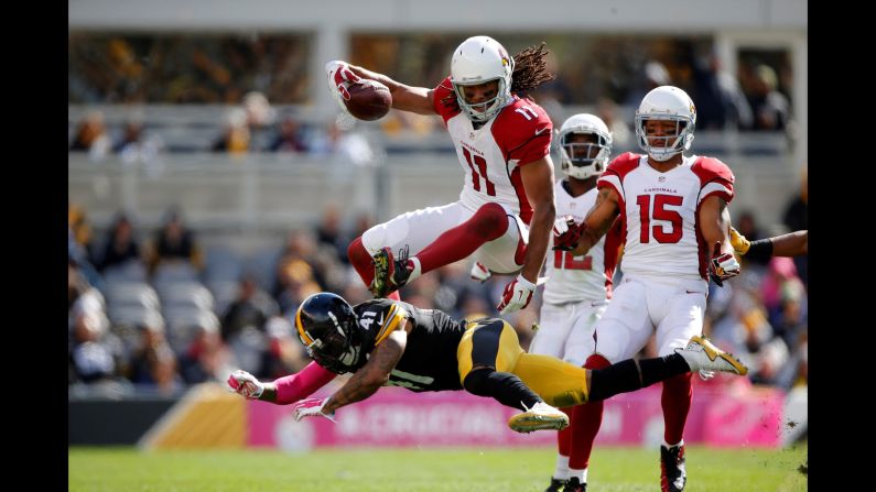 Arizona wide receiver Larry Fitzgerald jumps over a defender during an NFL game in Pittsburgh on Sunday, October 18.