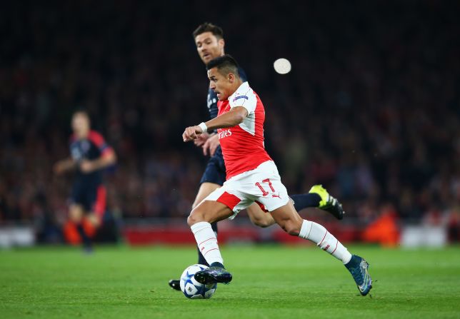  Alexis Sanchez of Arsenal is chased by Xabi Alonso of Bayern Munich during the UEFA Champions League Group F match between Arsenal FC and FC Bayern Munchen at Emirates Stadium.
