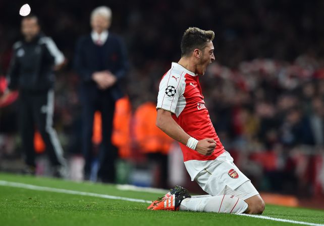 Arsenal's German midfielder Mesut Ozil (R) celebrates scoring his team's second goal during the UEFA Champions League football match between Arsenal and Bayern Munich at the Emirates Stadium in London.